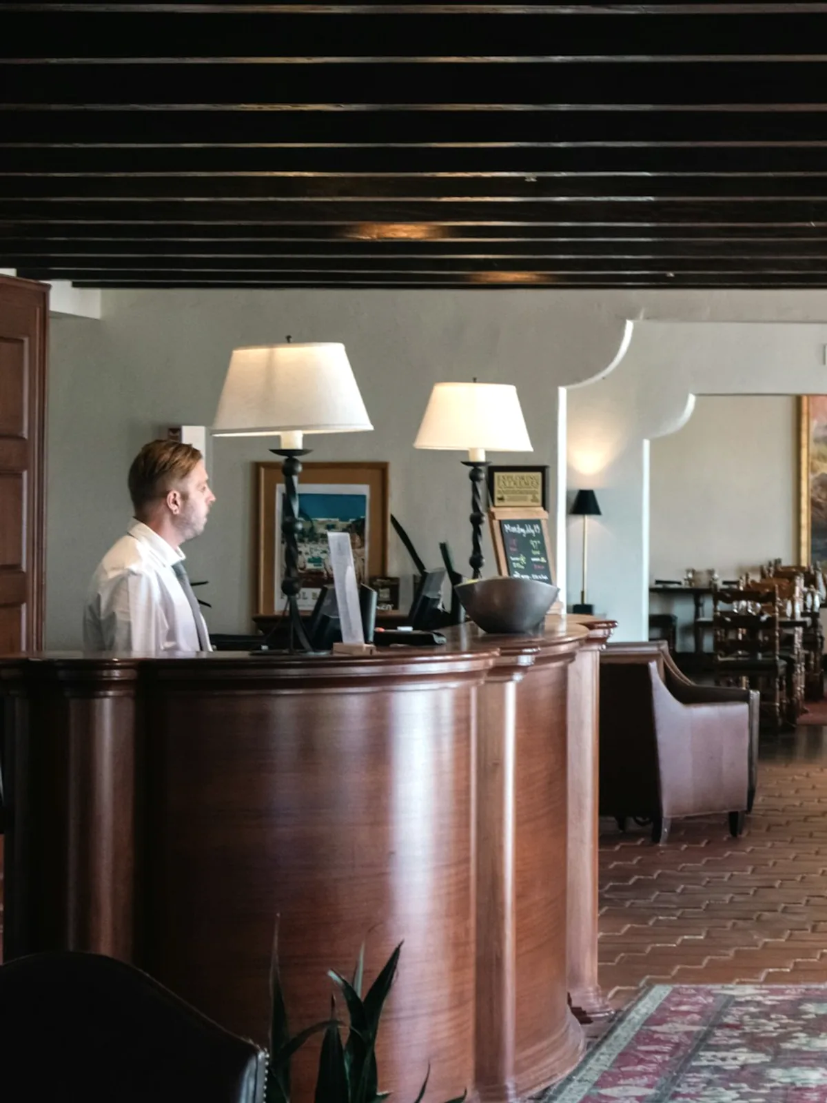 Rececionista a trabalhar no balcão de um hotel.