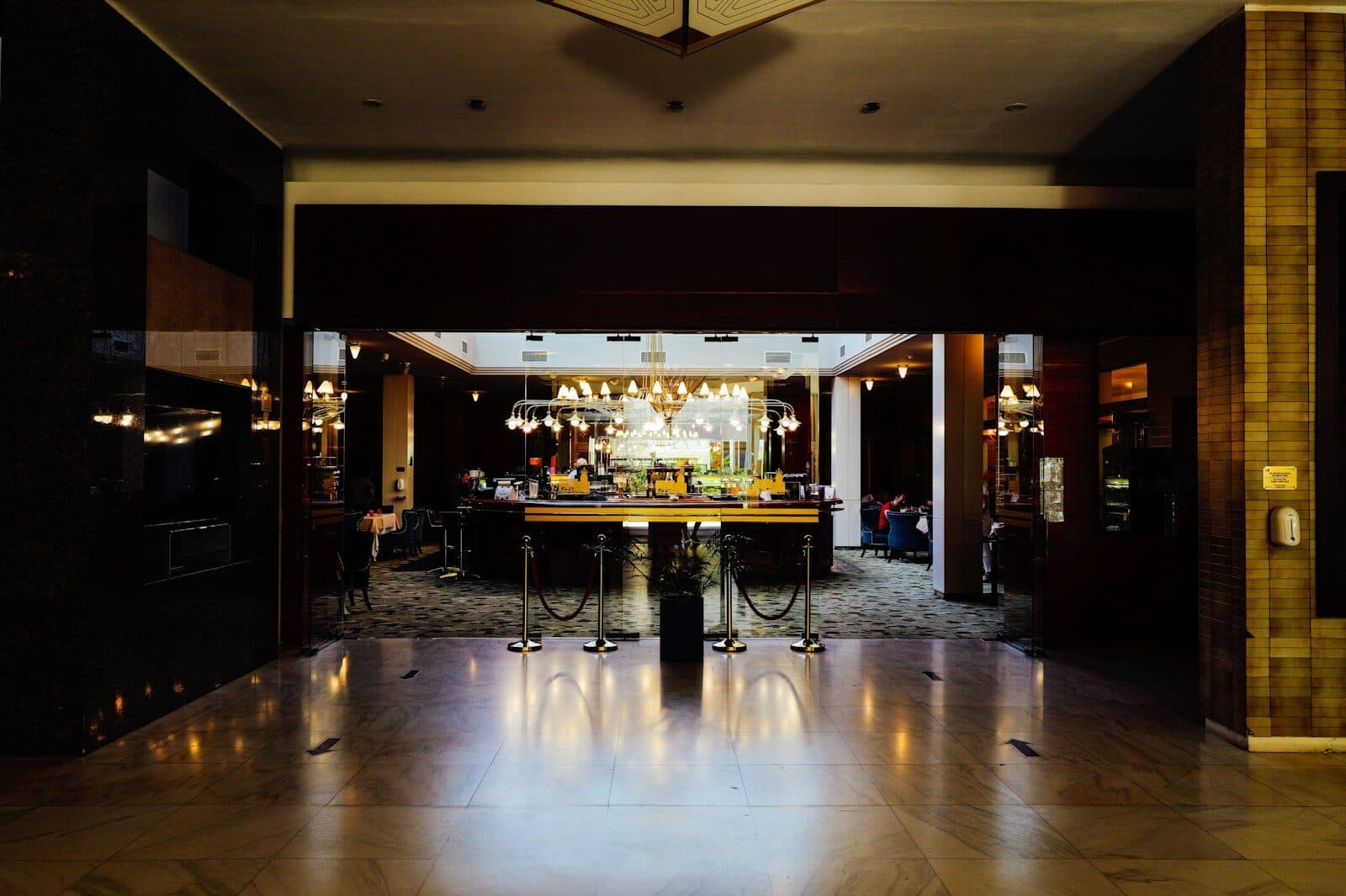 A view through a doorway into a dimly lit hotel lobby bar
